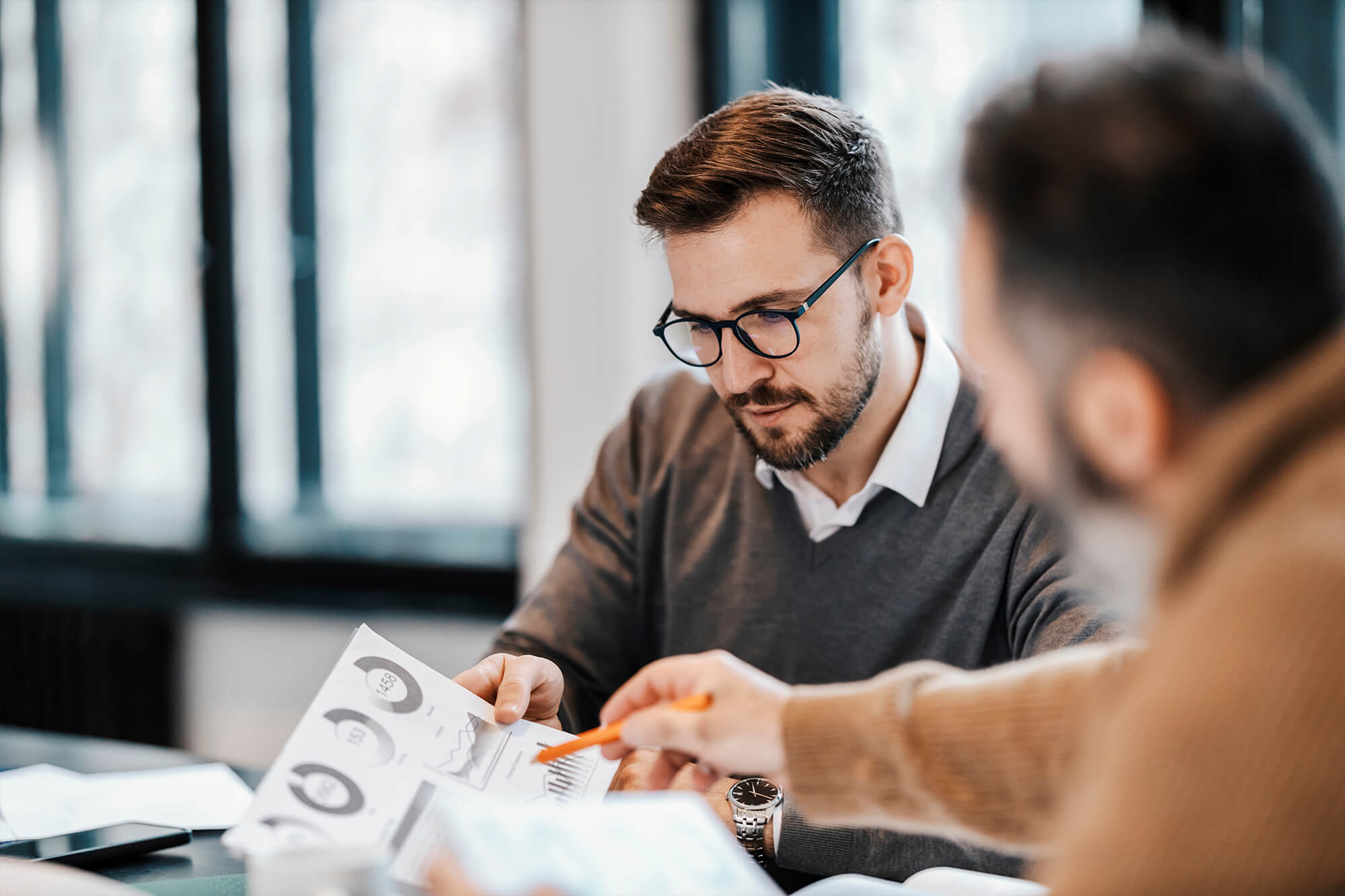 Two men looking over financial charts