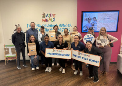 BCH team members and other volunteers holding signs inside the Kids' Meals office